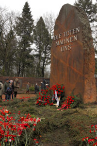 Foto einer 4 Meter hohen Stele mit der Aufschrift "Die Toten mahnen uns" in der Gedenkstätte der Sozialisten in Berlin